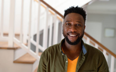 Headshot of Amir at his home, smiling.